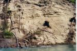 This is a picture of the banks of the Kenai River where there are small holes in the bank where birds nest.